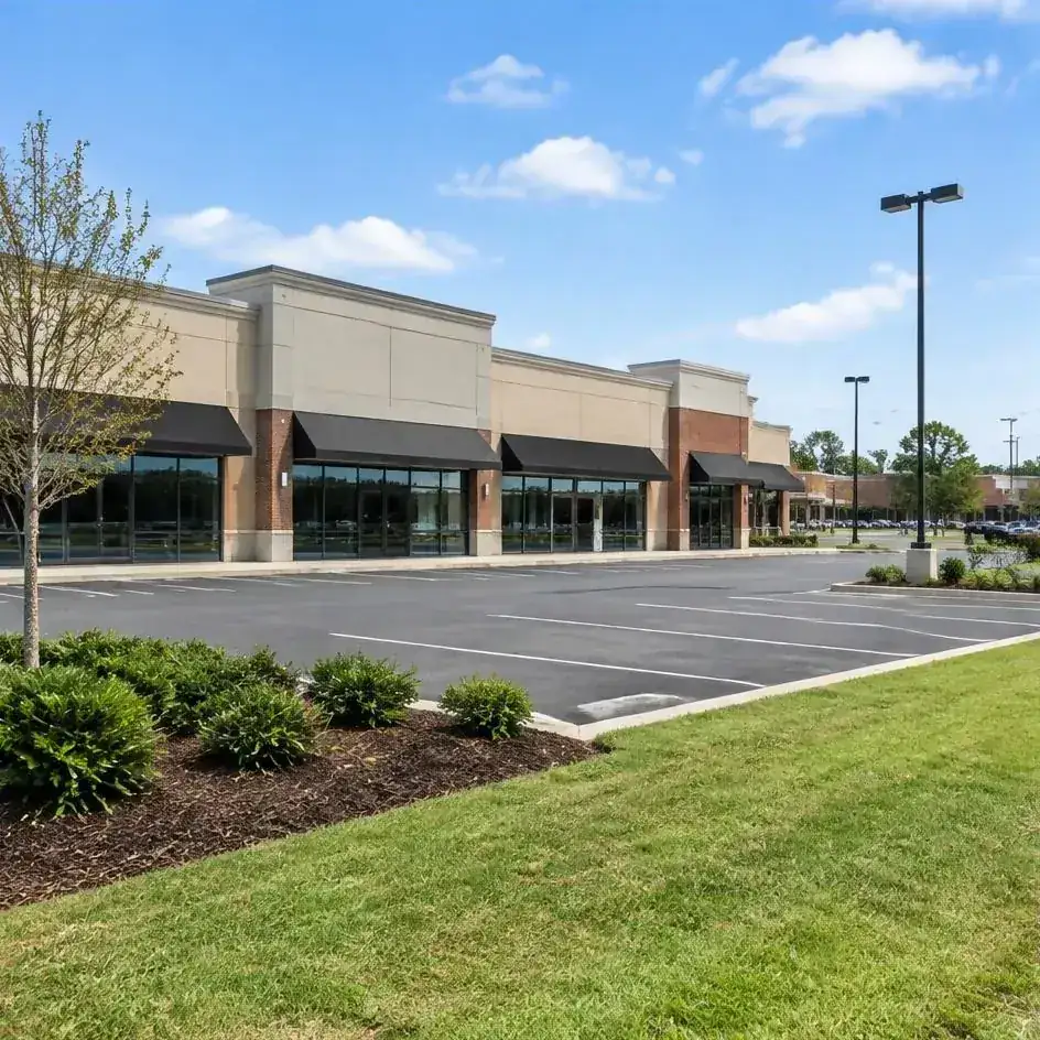 Retail storefronts with parking-area landscape beds and maintained grass verge